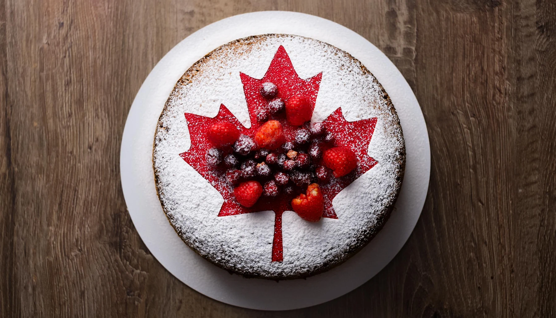 A maple leaf cake topped with berries